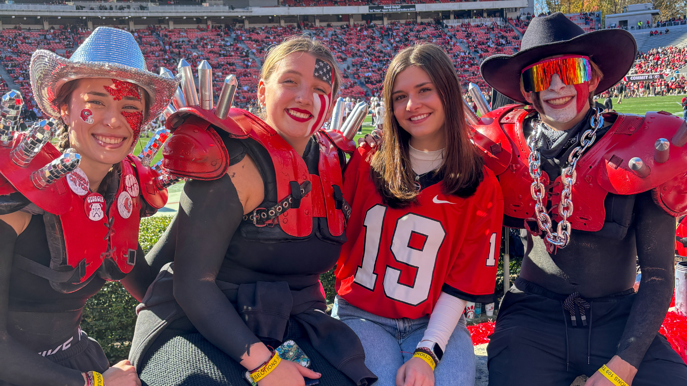 Group of students in the Spike Squad in UGA colors at a football game