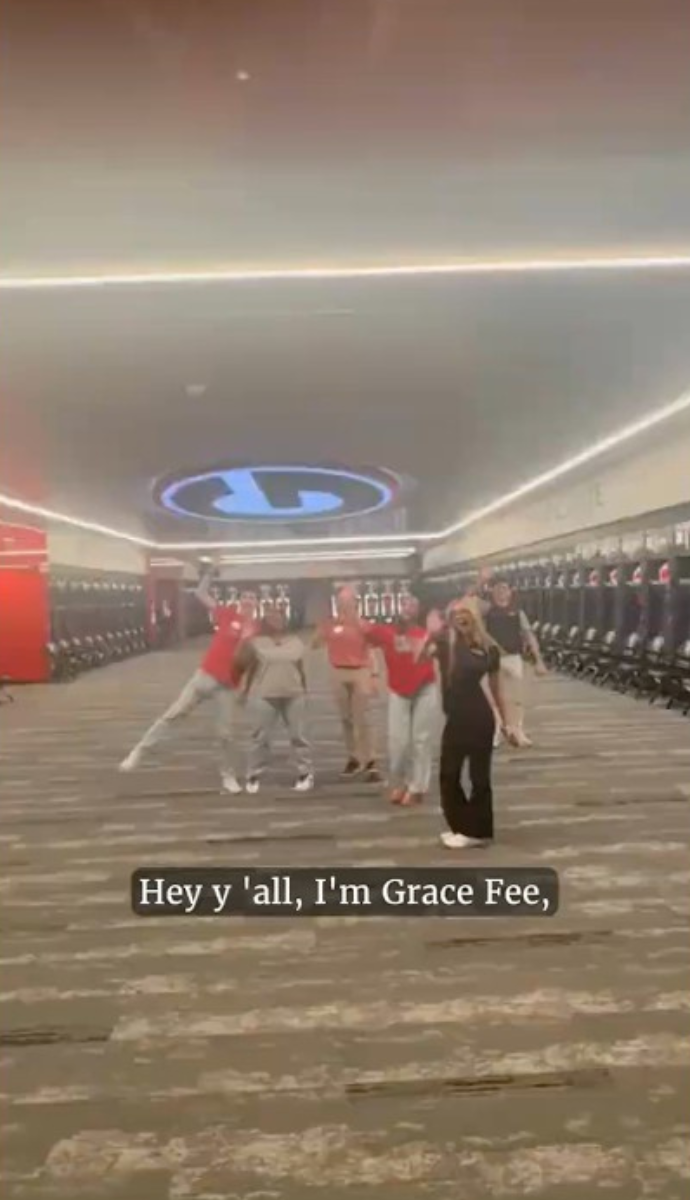 Students posing for a picture in the football locker room